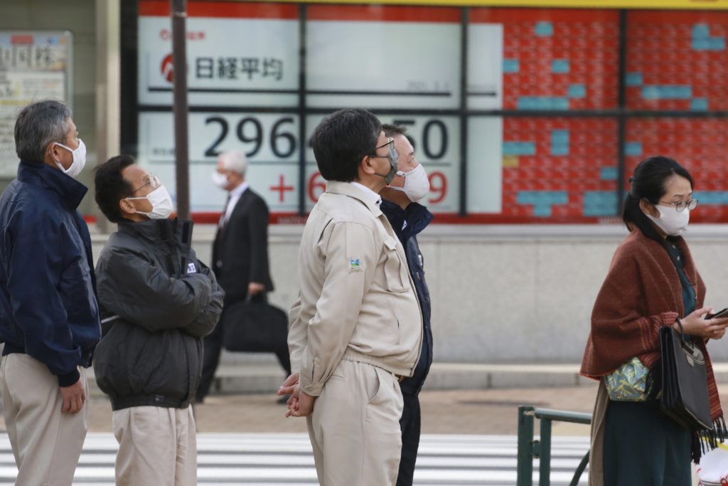 証券会社の株価表示板の前で足を止める人。2021 年 3 月 1 日、東京にて。( 記録、写真 / AP)