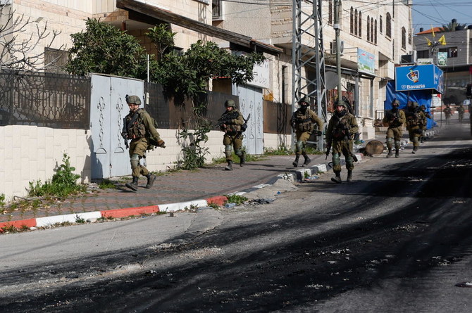 襲撃作戦中に街中を動き回るイスラエル兵たち、イスラエル占領下のヨルダン川西岸地区ジェニン市、2022年3月30日。（ロイター）