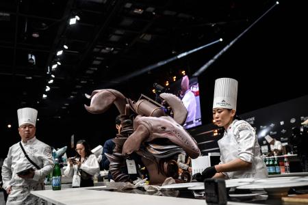 フランス南東部リヨン近郊のシャッシューエクスポ会場で開催されたSIRHA（Salon International de la Restauration, de l'Hôtellerie et de l'Alimentation）で2023年ボキューズ・ドール・パティスリー・コンクールに出場し、作品の準備をする日本チームの高橋萌氏（右）。　2023年1月21日　(AFP)