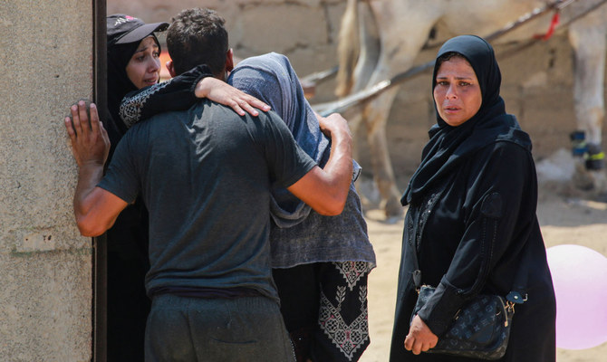 ガザ地区南部で、イスラエル軍の砲撃による死傷者の葬儀で慰め合うパレスチナ人。(AFP＝時事）