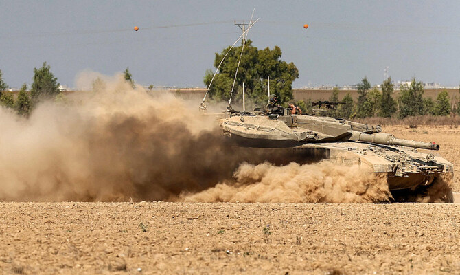 イスラエル軍の主力戦車が、イスラエル南部のガザ地区との国境沿いのフェンス付近を移動している。(AFP＝時事）