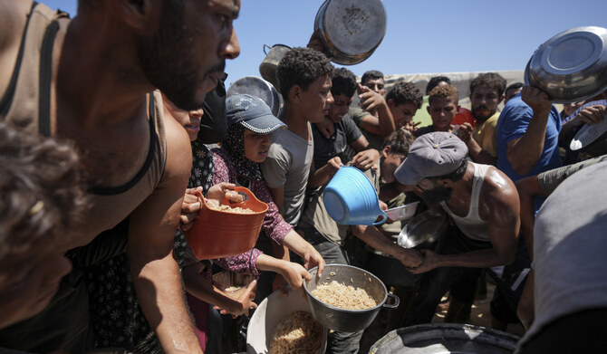 2024年8月23日、ガザ地区中央部のデイル・アル・バラで、食糧配給に集まる避難民のパレスチナ人。(AP)